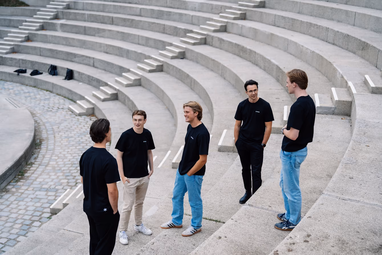 Five people talking on the steps of an open-air theatre.
