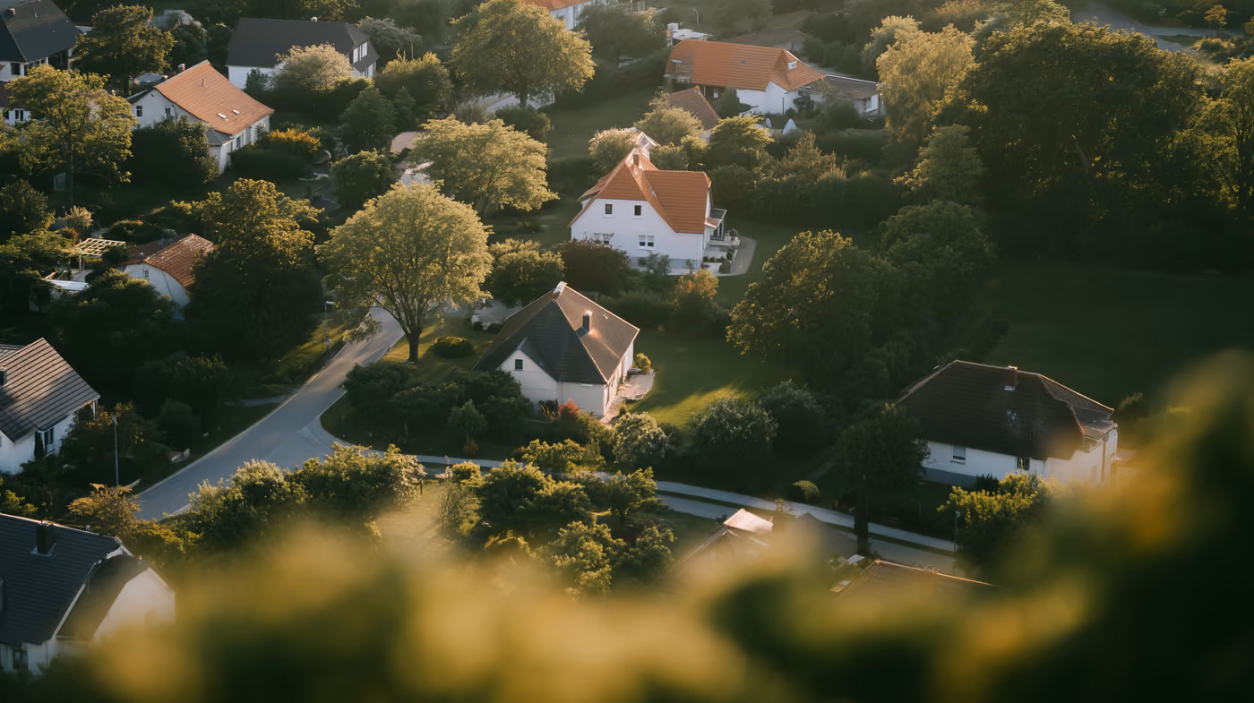 An aerial view of houses among trees.