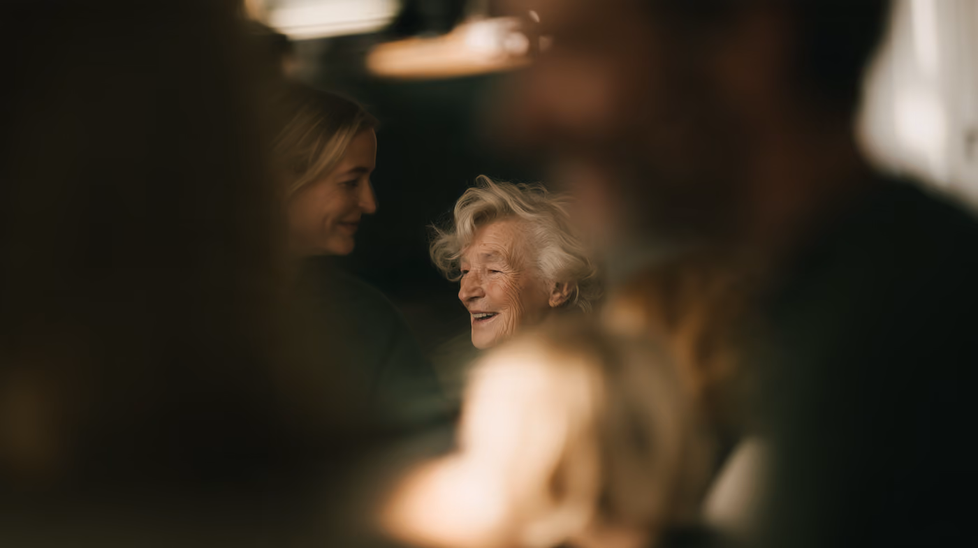 A younger and an older woman close together in warm light.