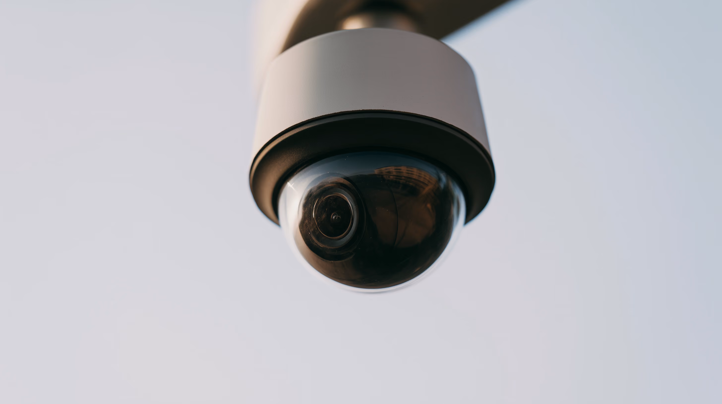 A dome camera close up against open sky.