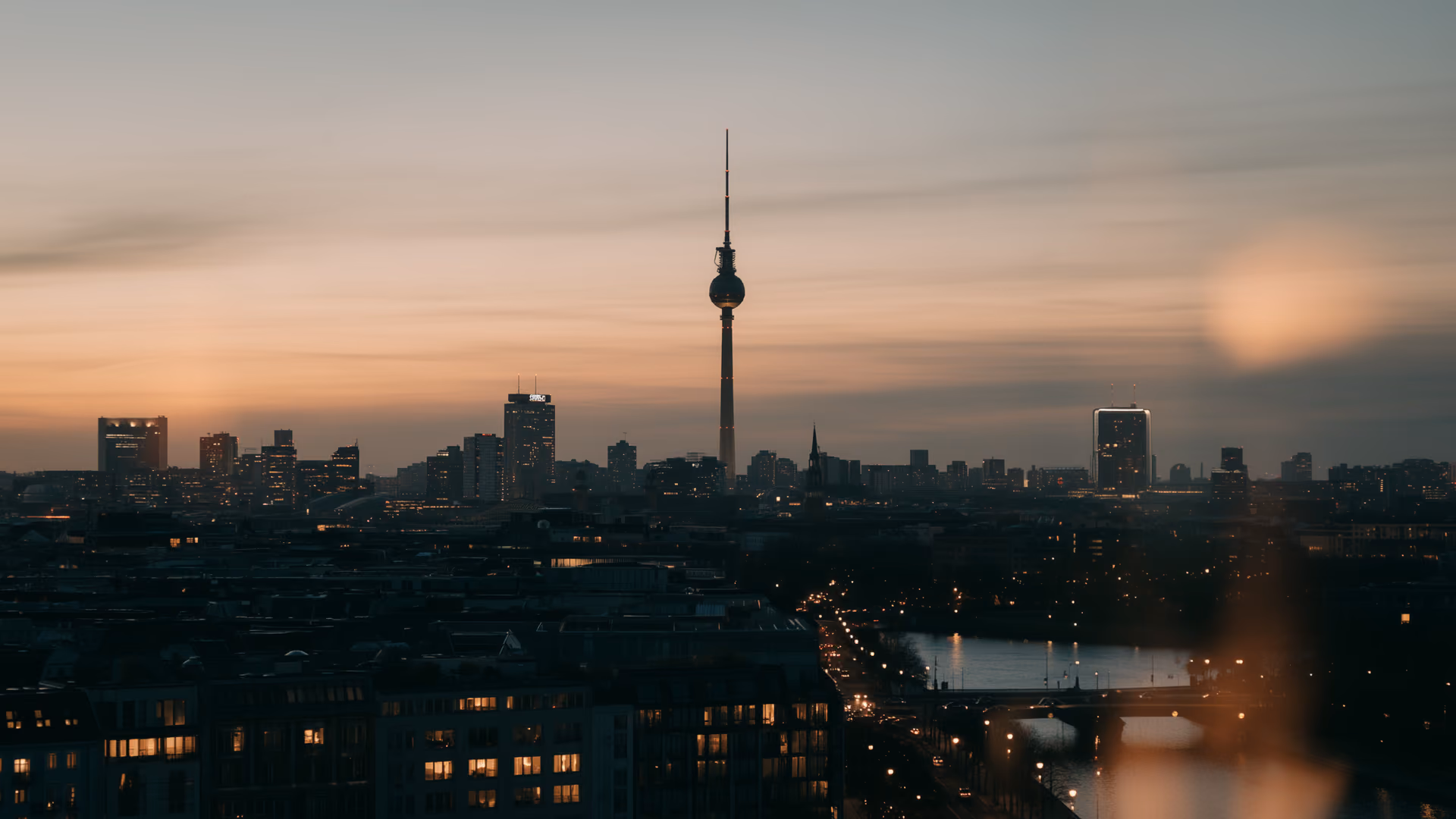 Central Berlin at dusk, the television tower above lit streets and buildings.