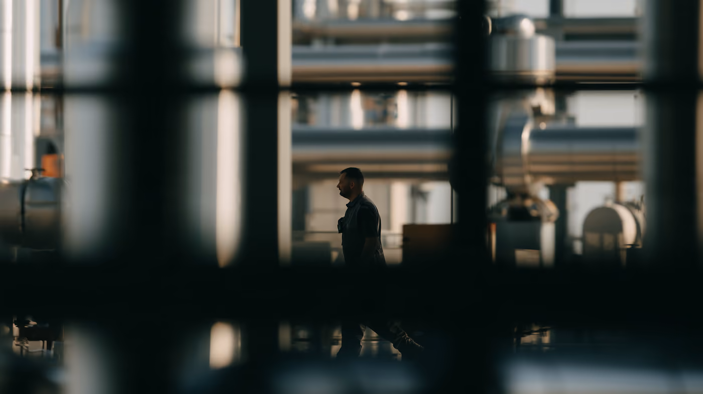 A single person walking through an industrial hall.