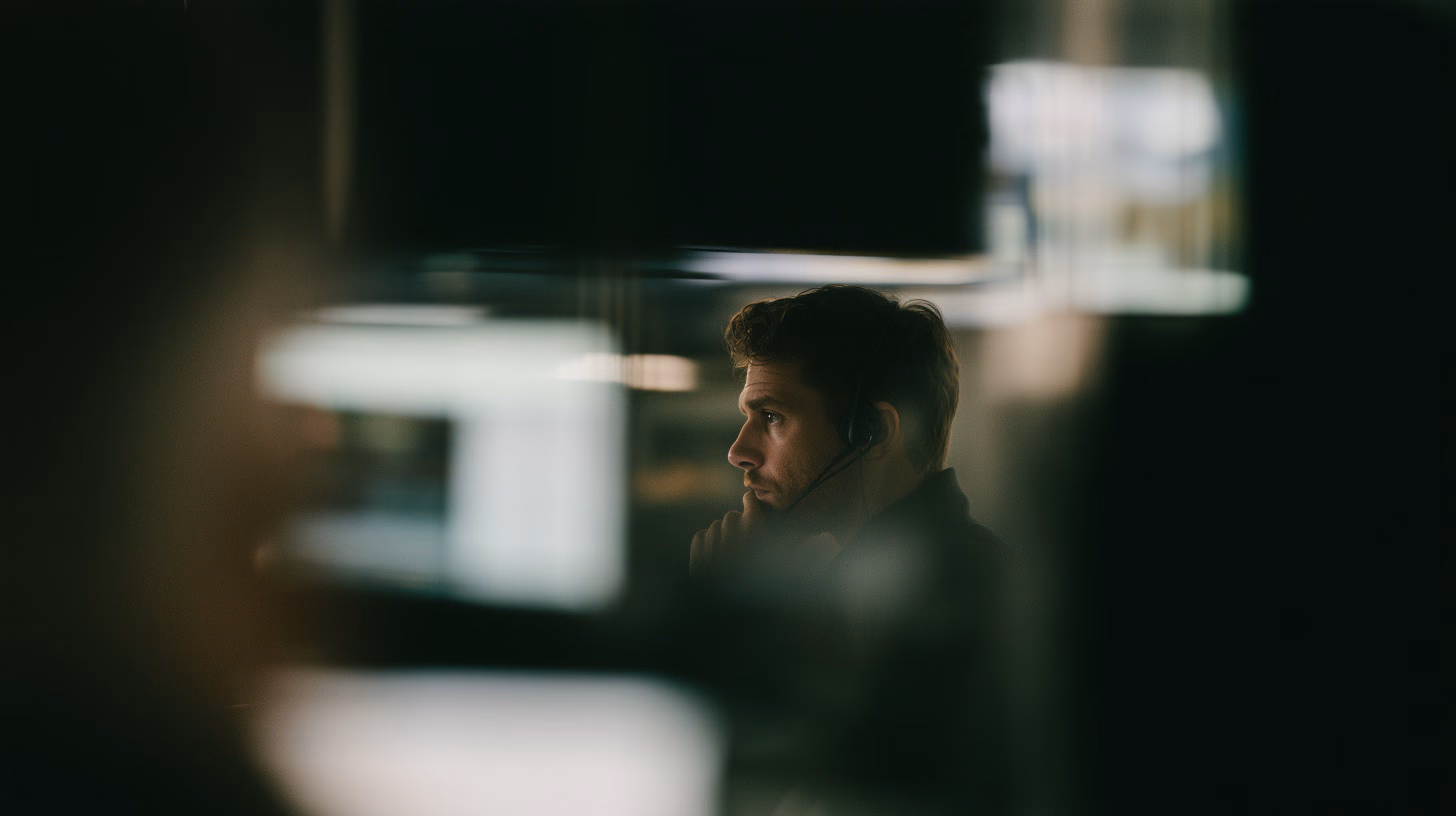 An out-of-focus interior, with a person at a workstation.