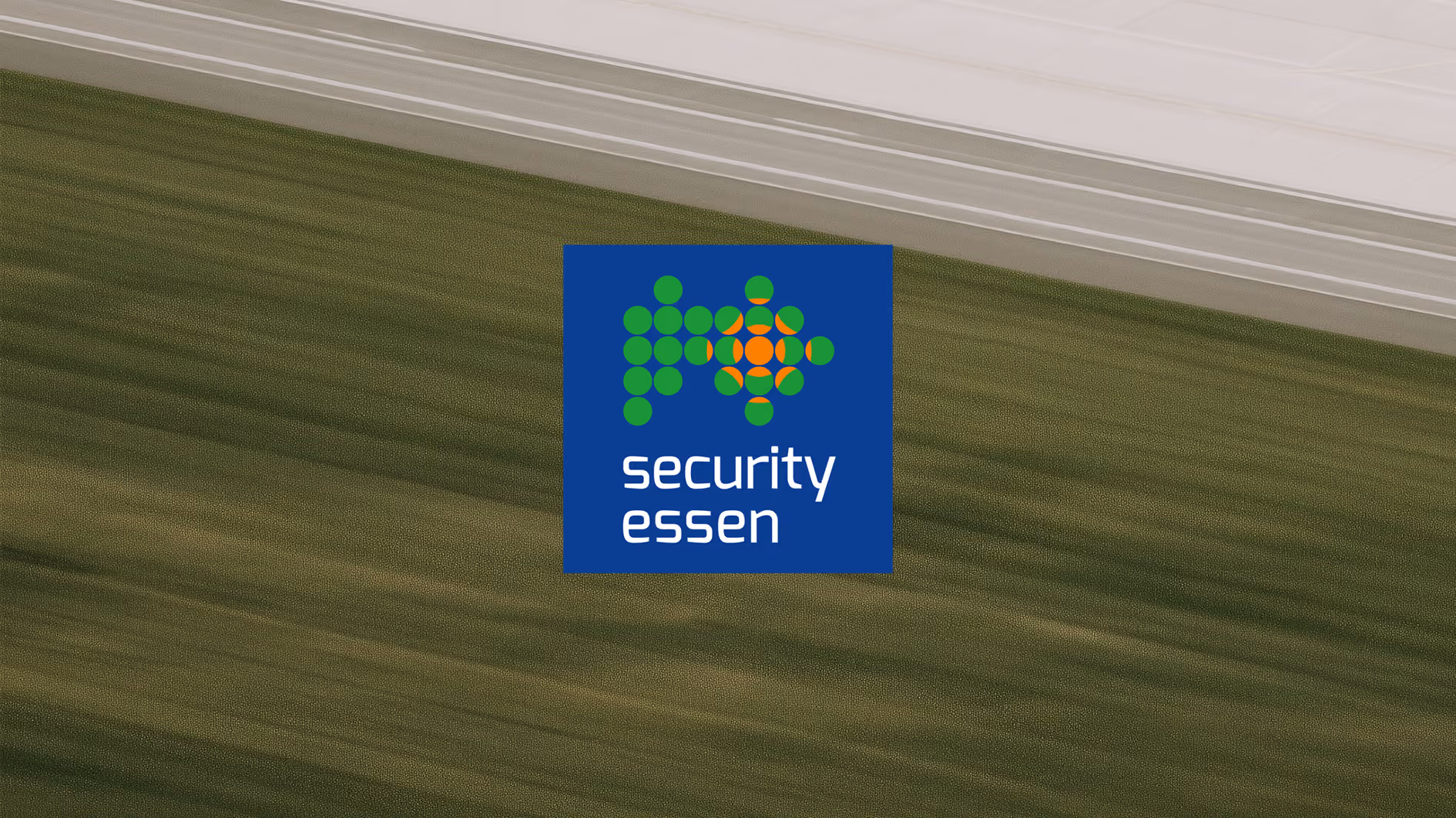 The Security Essen trade fair logo over an aerial view of open farmland.
